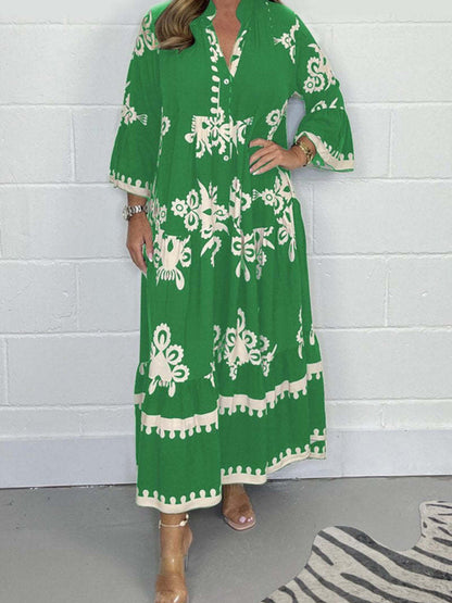 Person wearing a green dress with white patterns against a white brick wall.