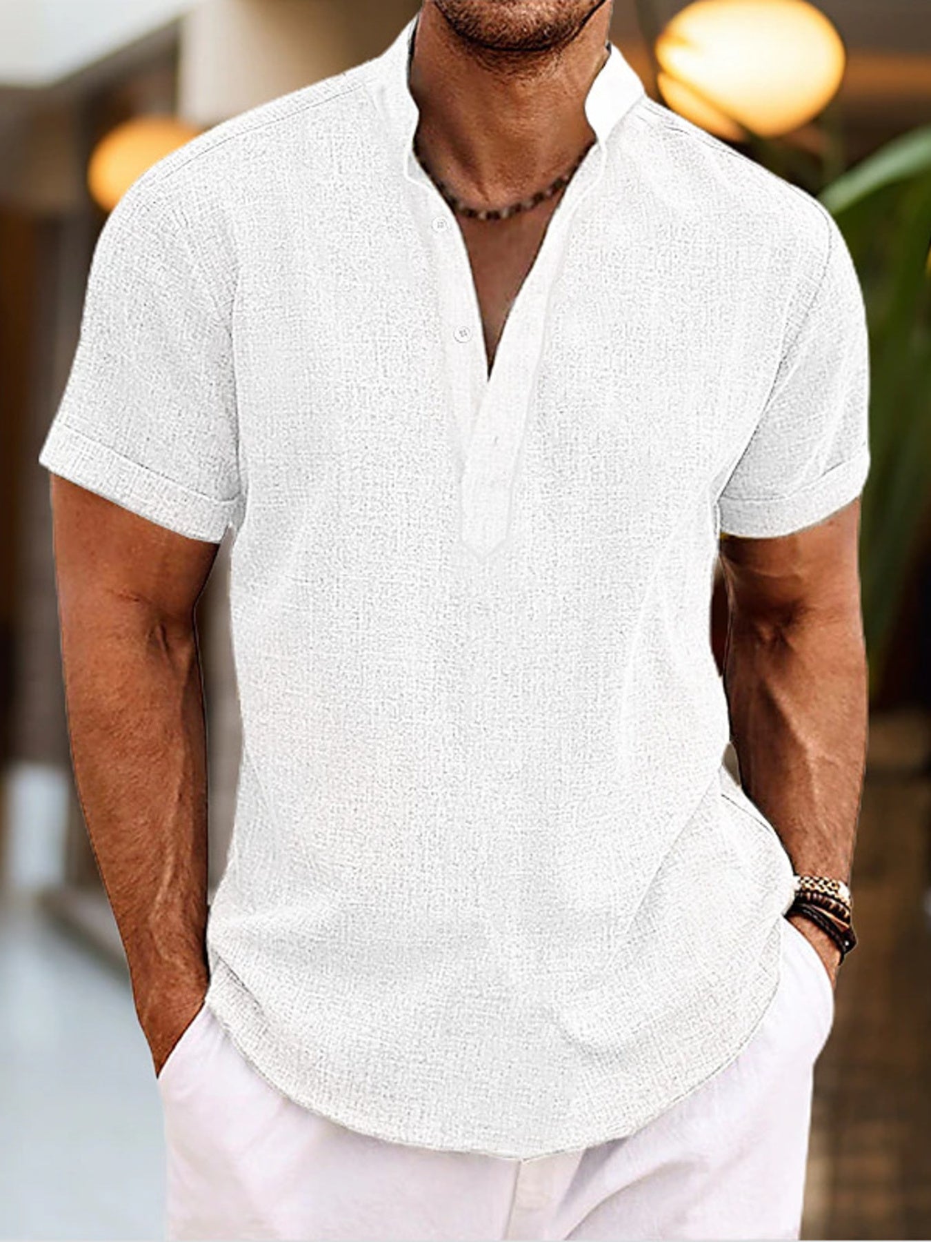 Man wearing a white short-sleeve shirt with a blurred background
