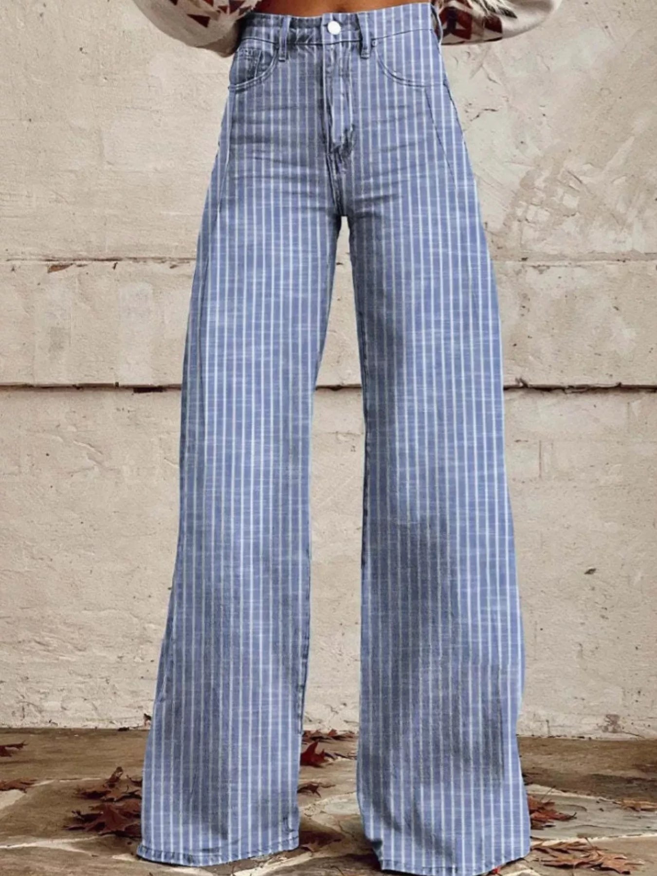 Blue plaid pants worn by a person against a textured wall.