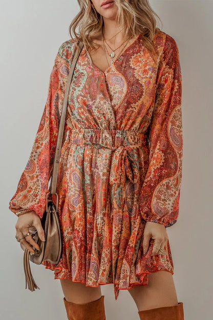 Woman wearing a patterned dress with long sleeves against a neutral background