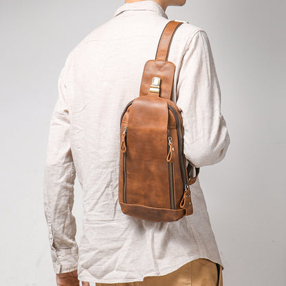 Person wearing a brown leather crossbody bag on a plain background