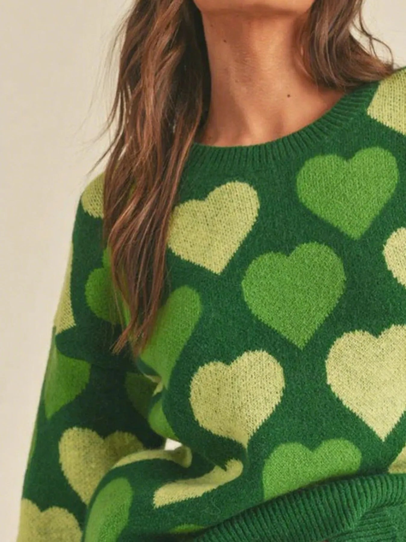 Green sweater with heart pattern worn by a person