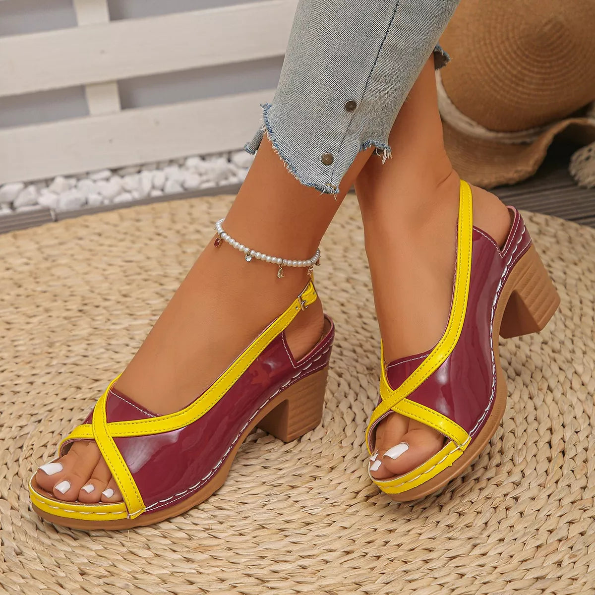 Yellow and Red sandal being worn on a patterned surface