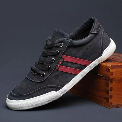 Black sneaker with red stripes on a wooden block against a dark background