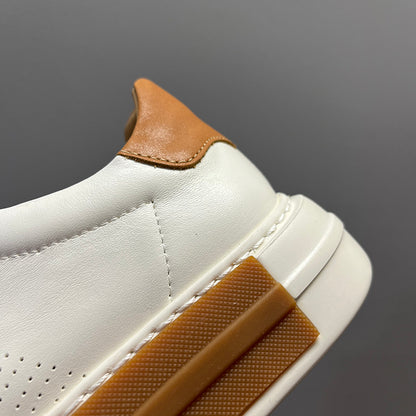 Close-up of a white sneaker with brown accents on a gray background