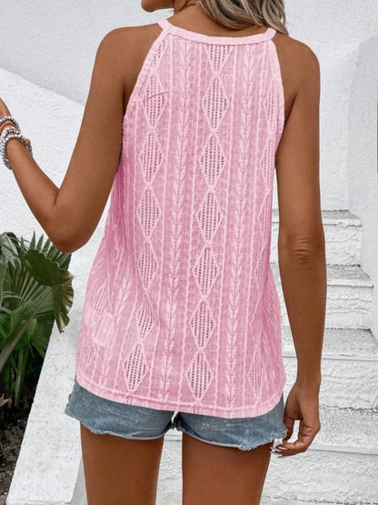 Person wearing a pink crochet tank top and denim shorts outdoors.
