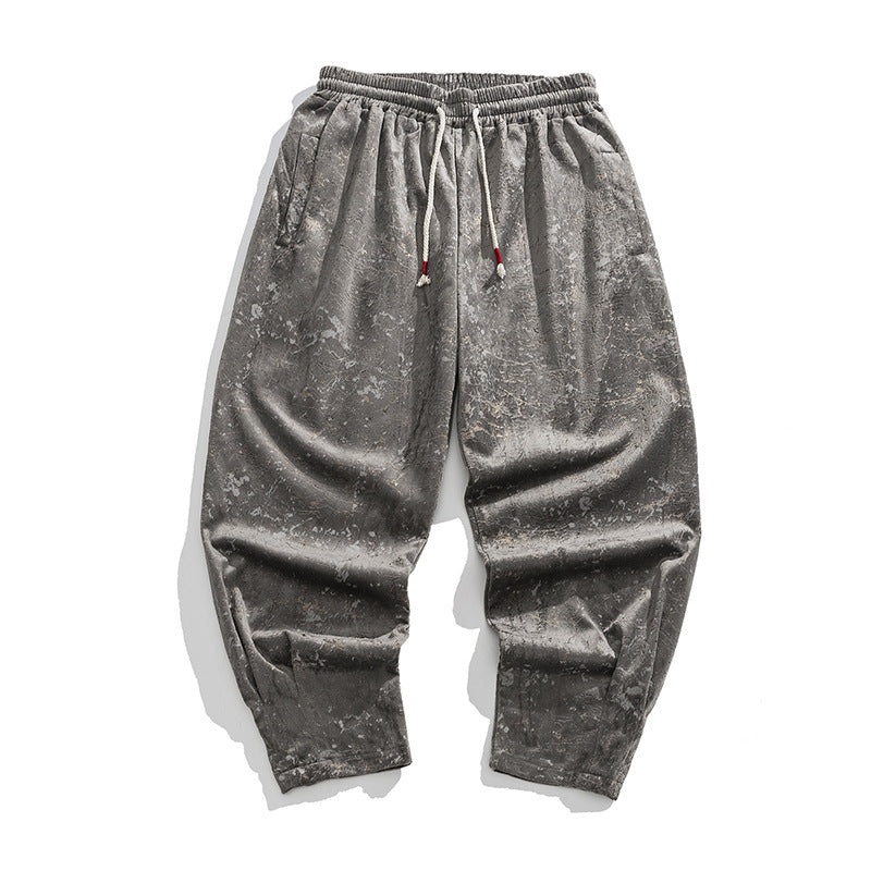 Gray distressed pants with a drawstring on a white background
