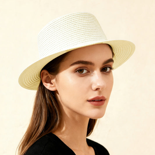 Woman wearing a straw hat against a beige background
