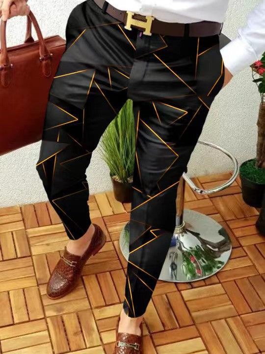 Person wearing black pants with gold patterns, standing on a wooden floor.