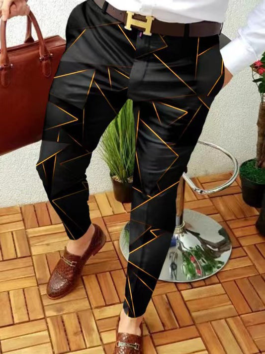 Person wearing black pants with gold patterns, standing on a wooden floor.
