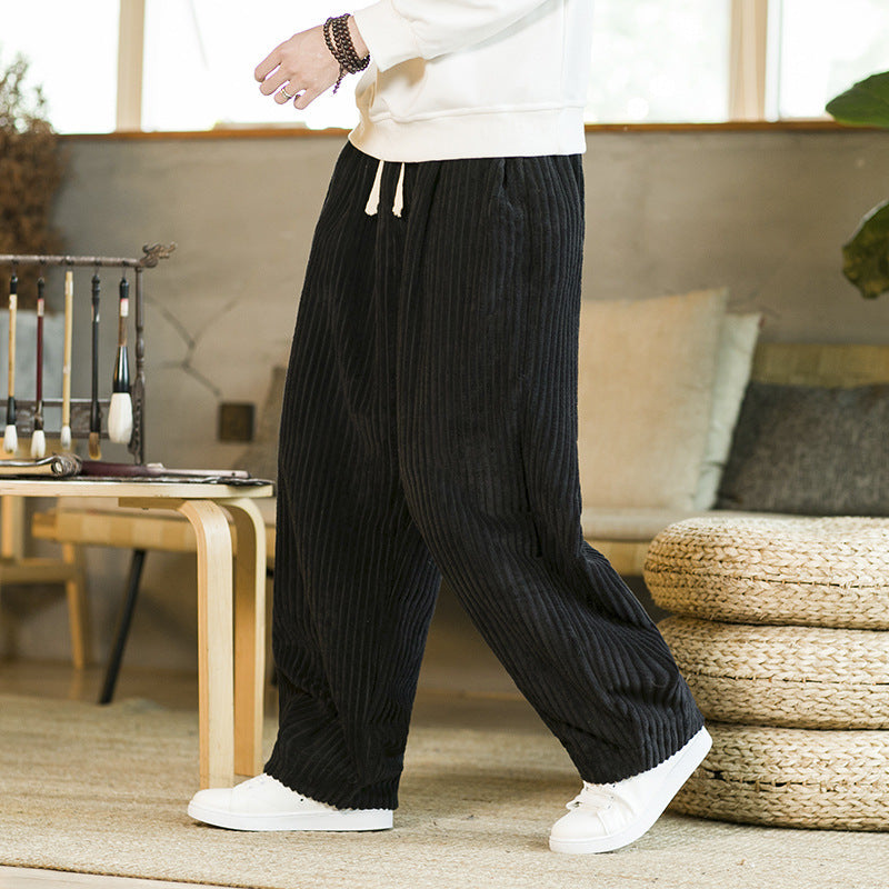 Person wearing black ribbed knit pants in a living room setting