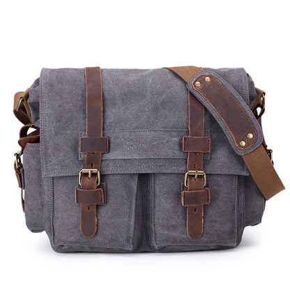 Gray canvas bag with brown leather straps on a white background