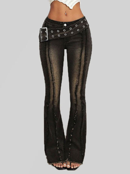 Black flared jeans with studded details on a gray background