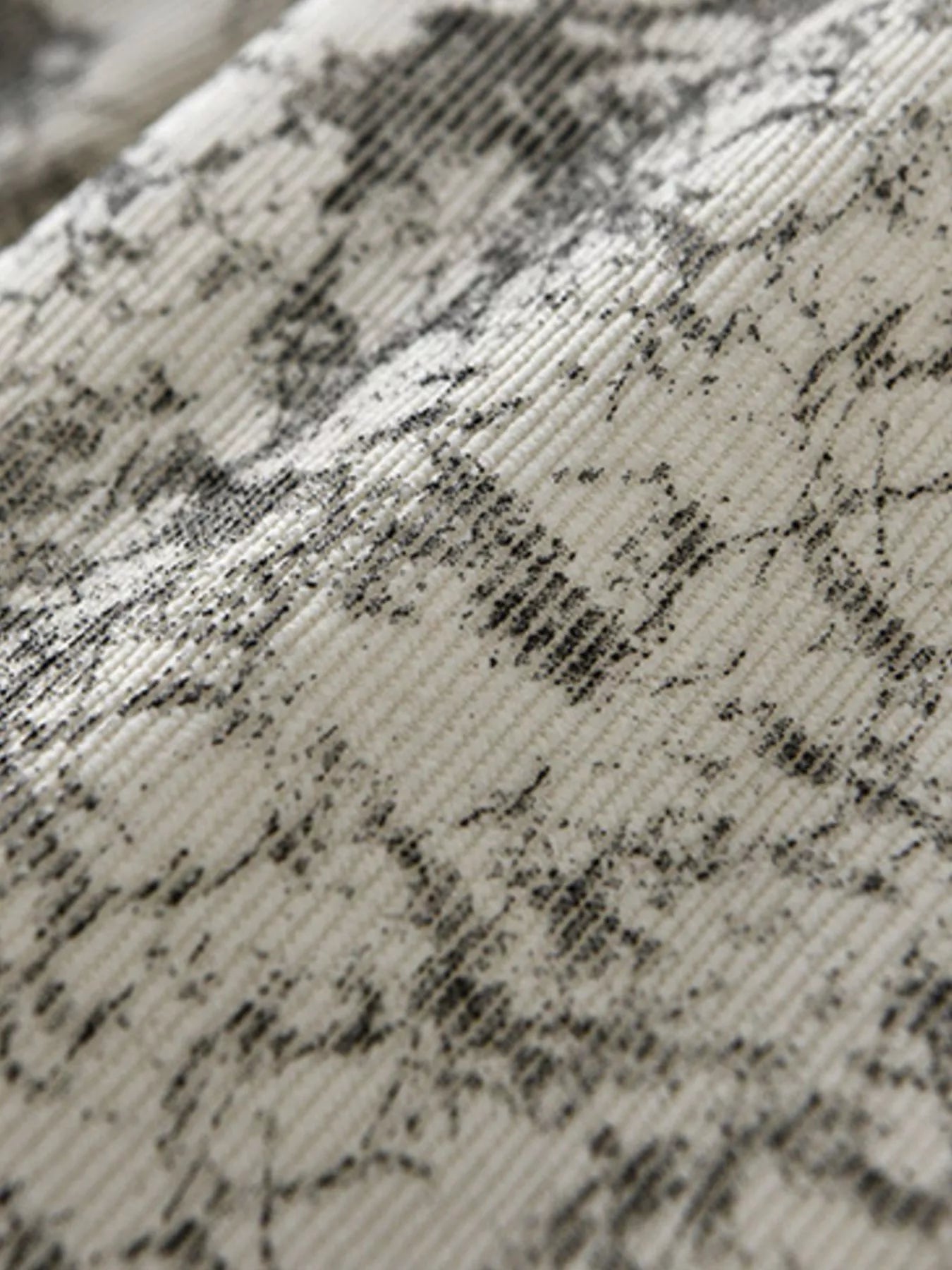 Close-up of textured fabric with black pattern on beige background