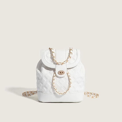 White quilted handbag with a gold chain on a light beige background