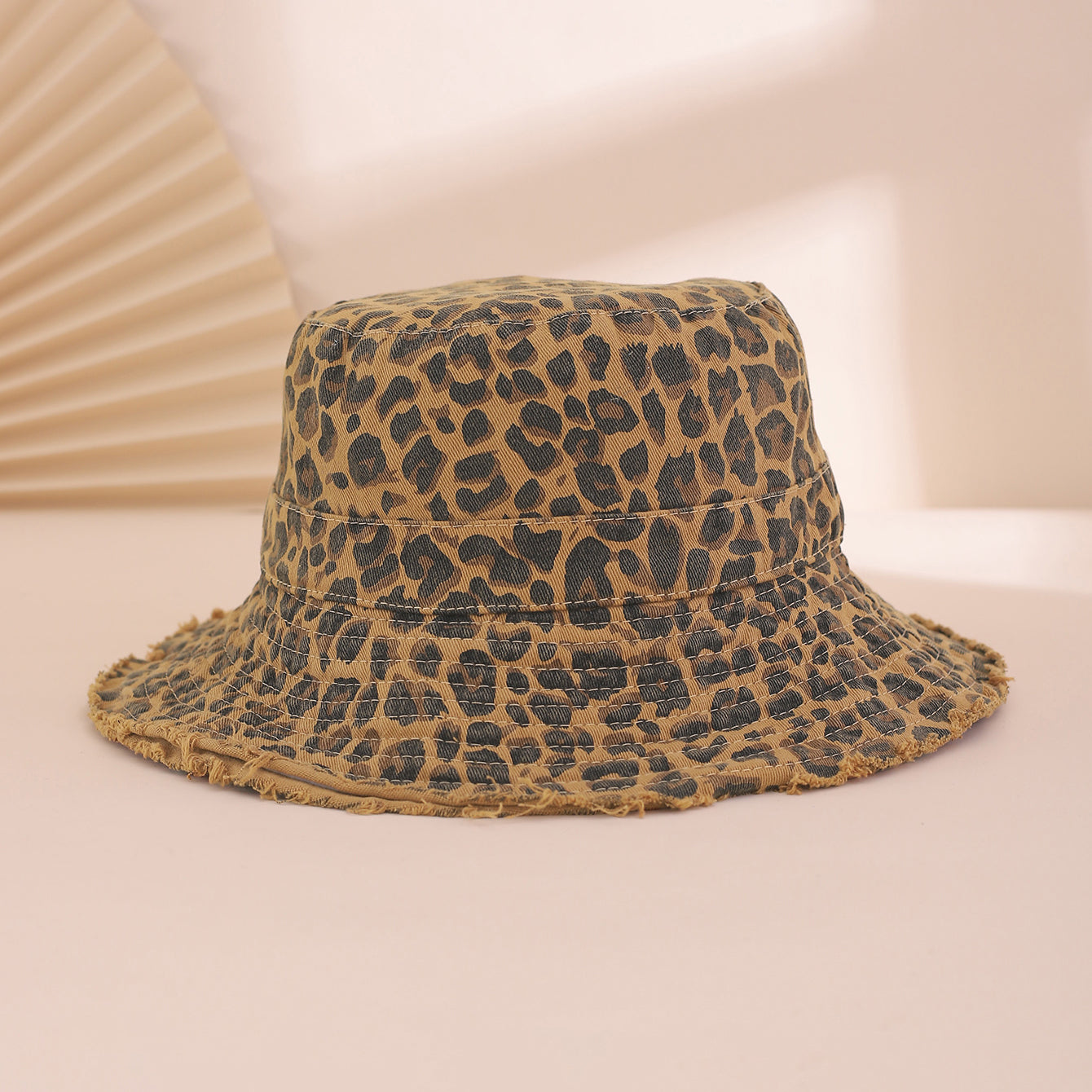 Leopard print bucket hat on a light pink background