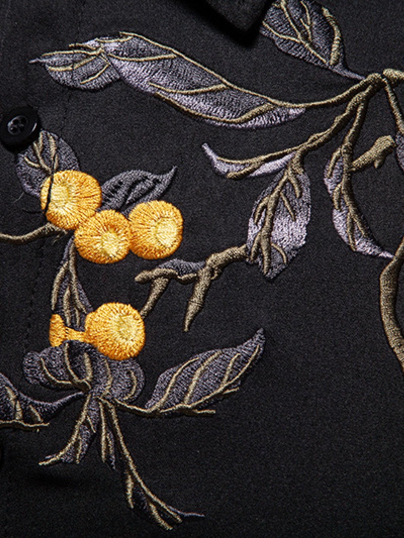 Close-up of embroidered floral design on a dark fabric background