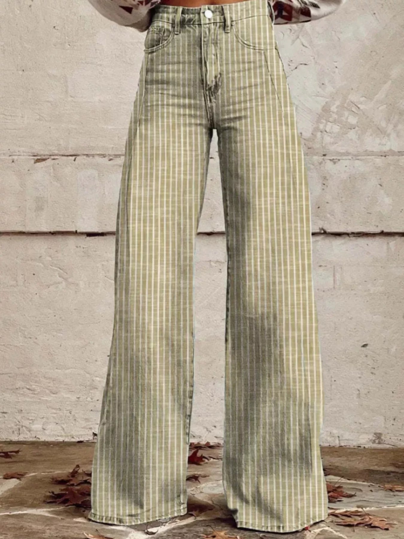 Green plaid pants worn by a person against a concrete wall.