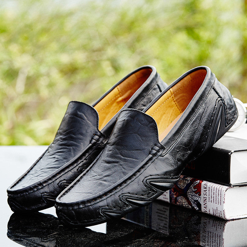 Bllack loafers with a blurred green background
