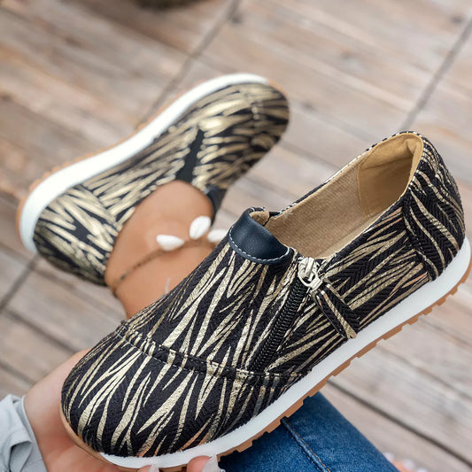 Zebra print shoes worn by a person on a wooden floor.