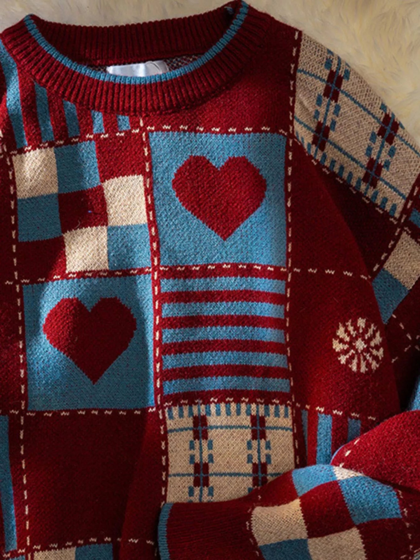 Colorful patchwork sweater with heart patterns on a textured background
