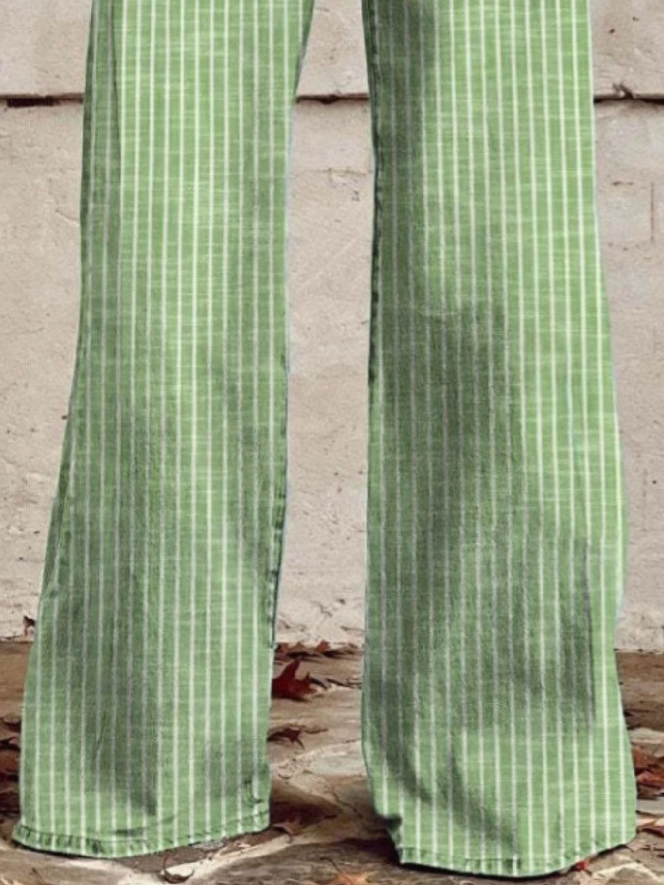 Green striped pants against a brick wall.