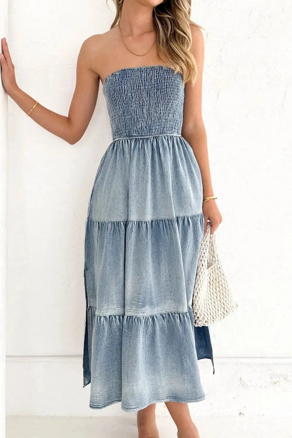 Woman wearing a strapless denim dress with a white background