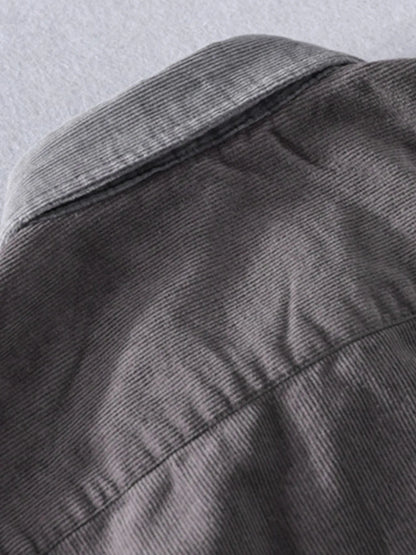 Close-up of a gray jacket with a textured pattern on a light gray background