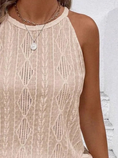 Close-up of a person wearing a beige lace top with a white background