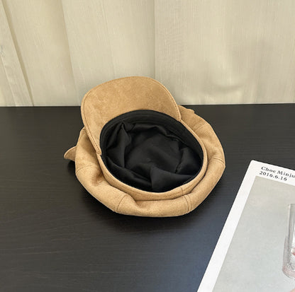 Beige pet bed on a dark surface with a beige wall in the background