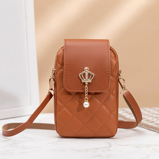 Brown quilted phone bag with a decorative crown charm on a light background