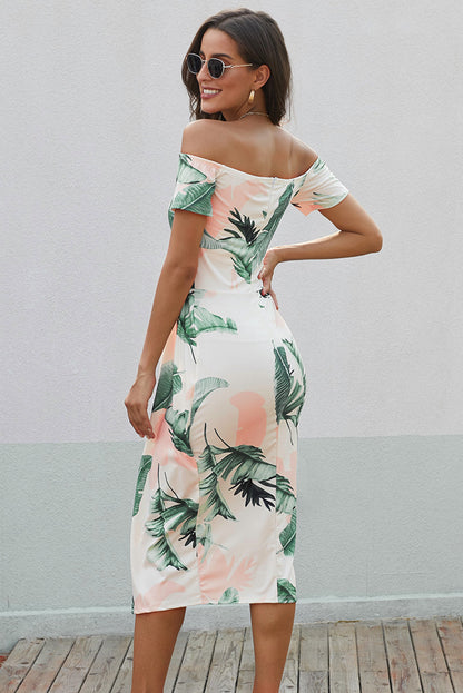 Woman wearing a tropical print dress with a plain background