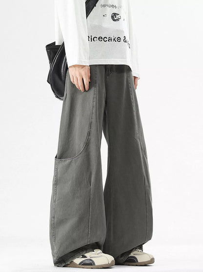 Person wearing gray wide-leg pants with a white shirt featuring text on a white background