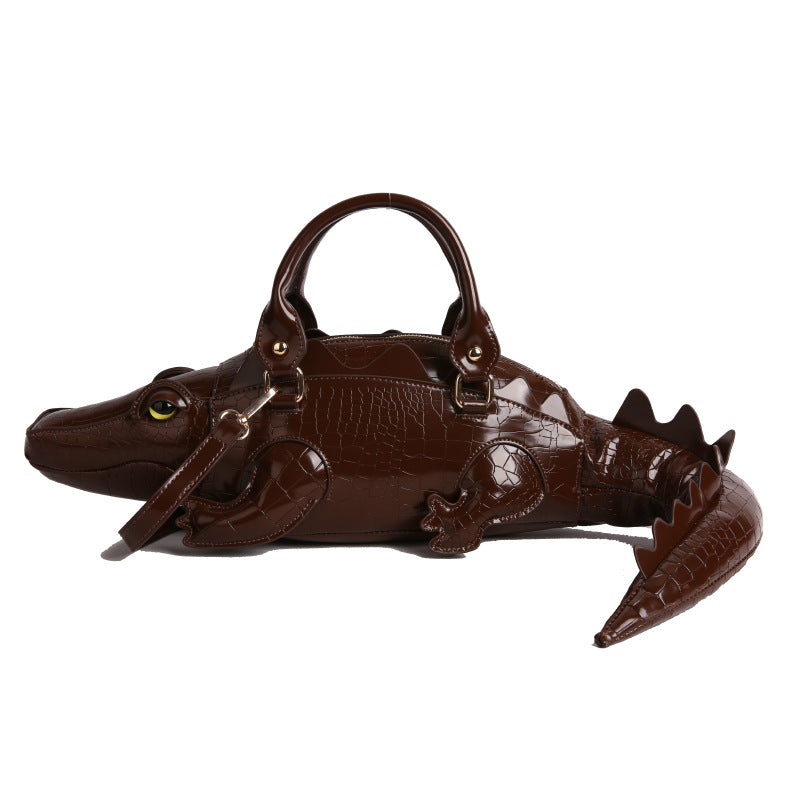 Brown alligator-shaped handbag on a white background