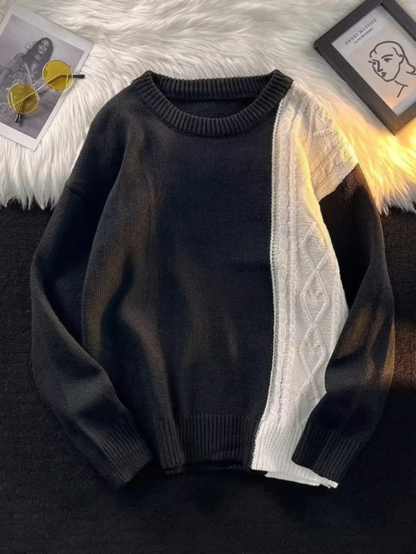 Black sweater with white lining on a textured surface