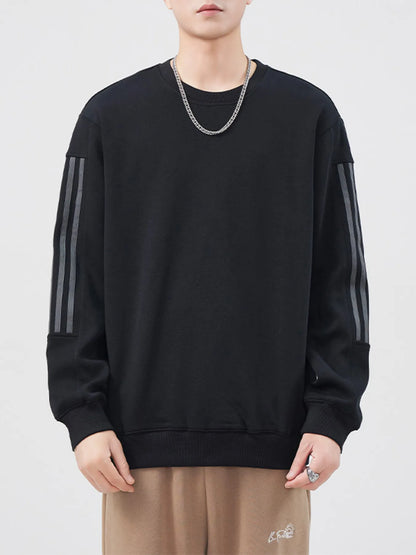 Person wearing a black sweatshirt with gray stripes on a white background