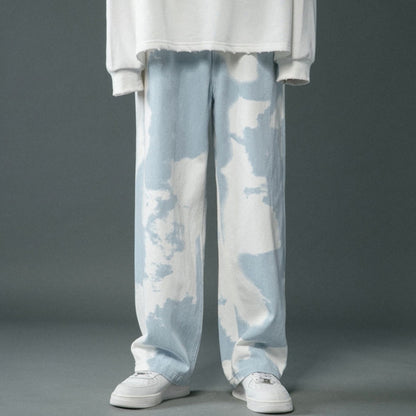 Light blue tie-dye pants worn with a white top on a gray background