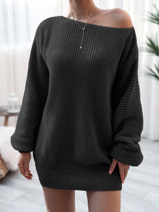 Person wearing a black off-shoulder sweater in a neutral indoor setting