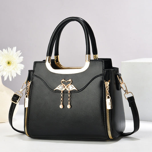 Handbag with gold accents with a single flower and white background.