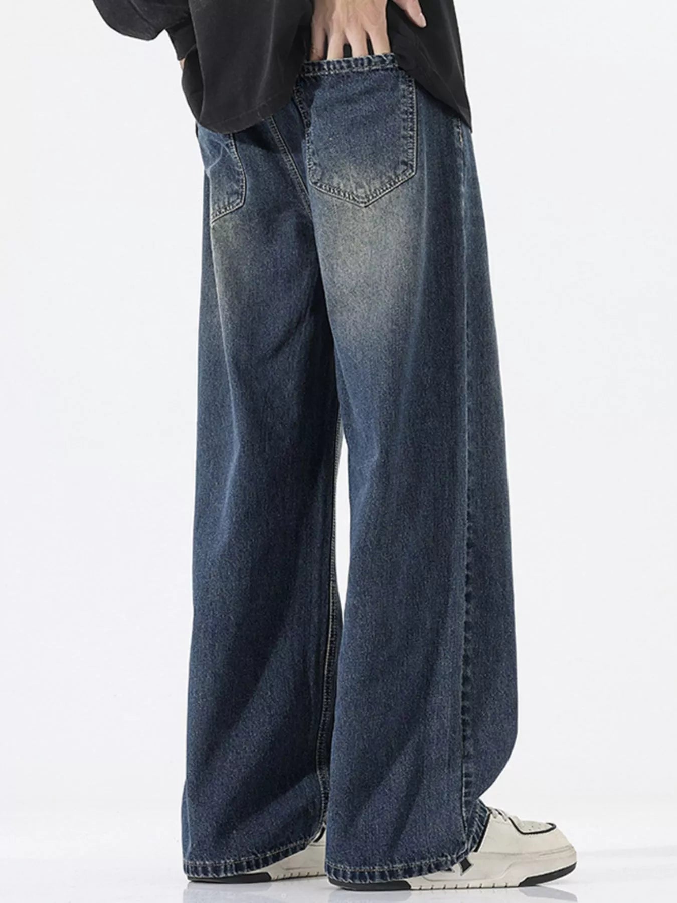 Person wearing wide-leg jeans on a white background