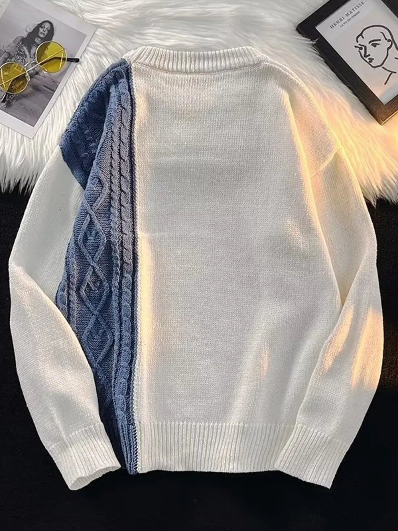 White sweater with blue patterned lining on a dark background