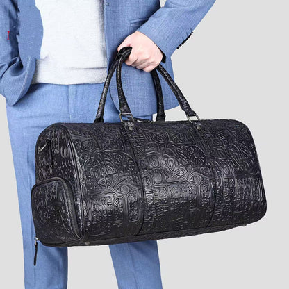 Person holding a black embossed duffel bag against a light gray background
