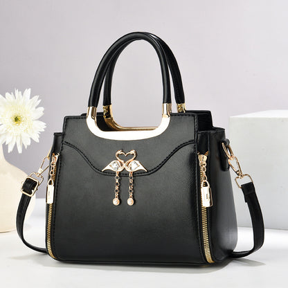 Handbag with gold accents with a single flower and white background.
