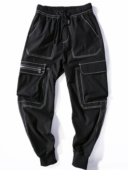Black cargo pants with white stitching on a white background