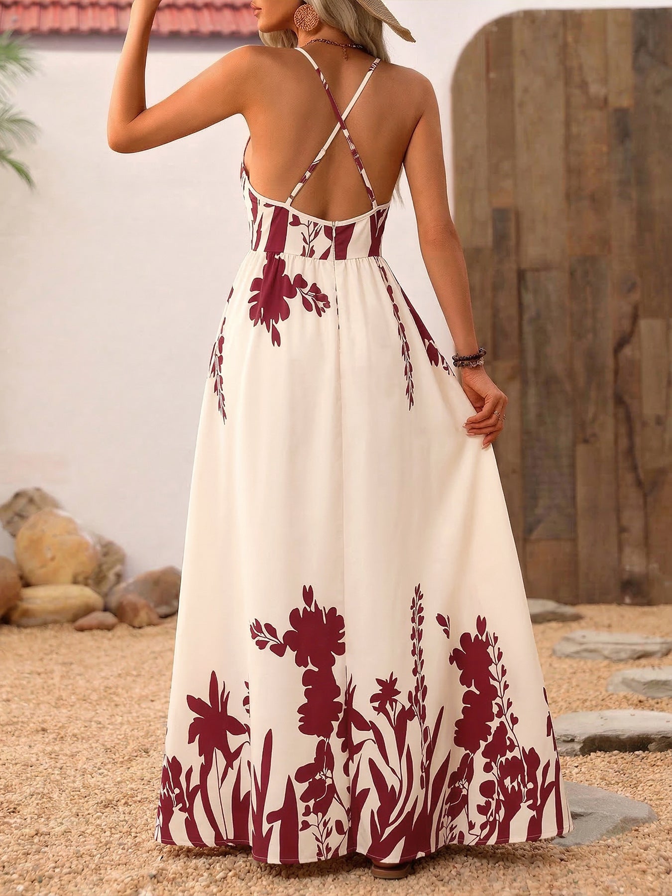 Woman wearing a white dress with red floral patterns in an outdoor setting.