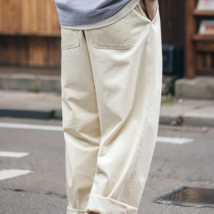 Person wearing beige pants on a street with blurred background