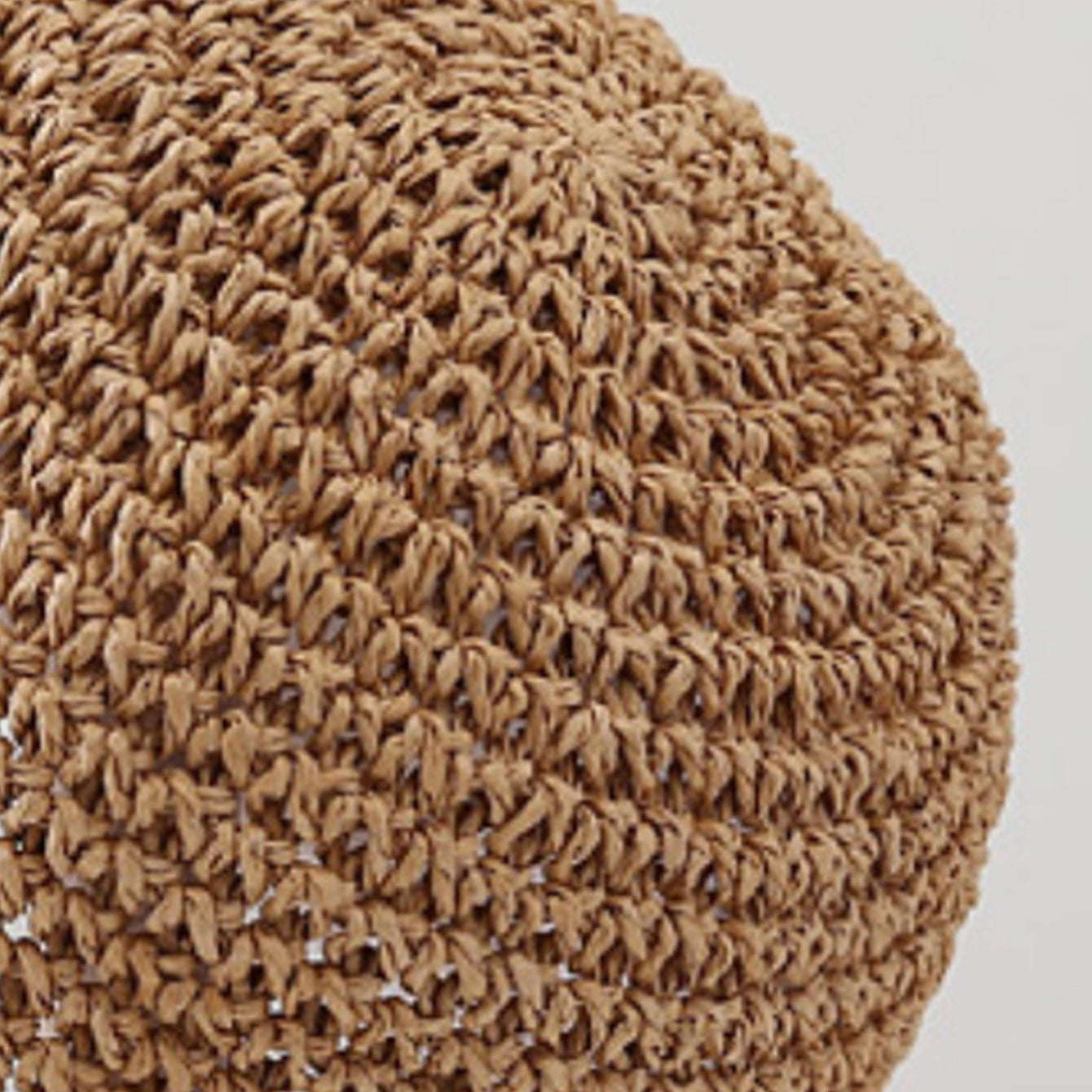 Close-up of a textured brown fabric sphere on a light gray background