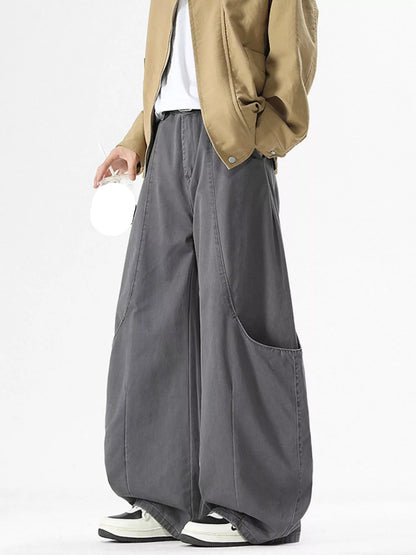 Person wearing a beige jacket and gray wide-leg pants on a white background