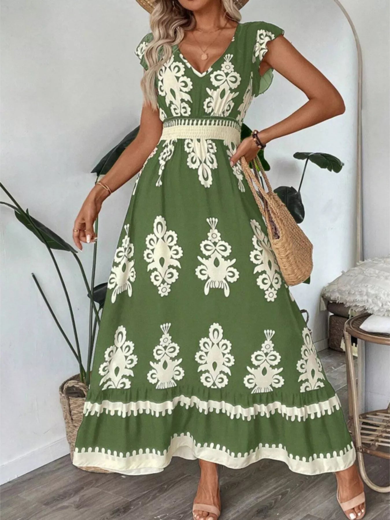 Woman wearing a green dress with white patterns in an indoor setting.