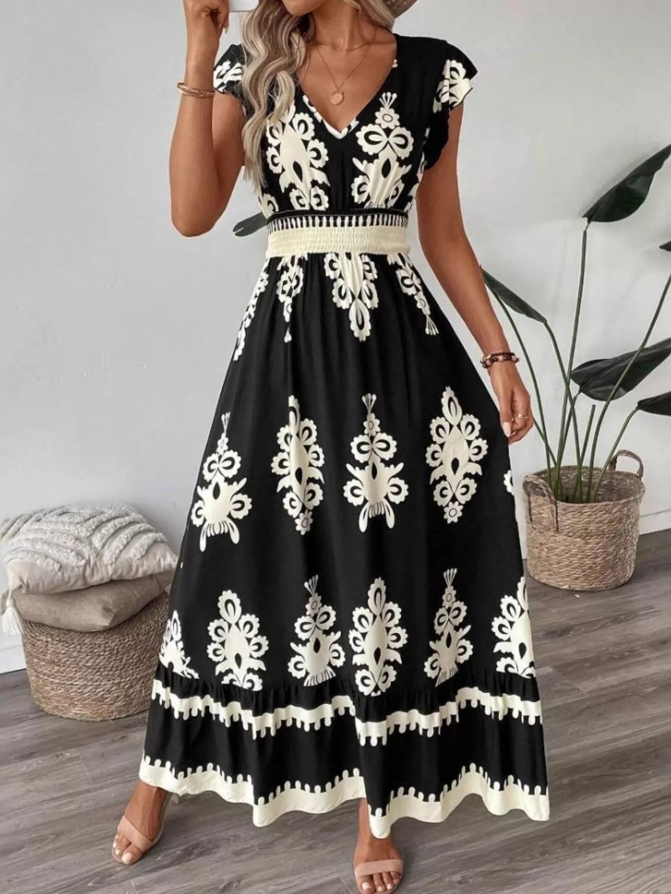 Black dress with white floral patterns worn by a person indoors.